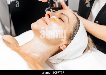 La cliente profite du traitement de rajeunissement facial RF lifting dans un environnement spa serein, mettant en évidence les techniques de soins de la peau et l'atmosphère apaisante Banque D'Images