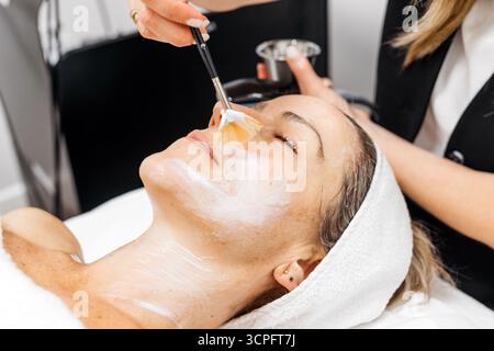 La cliente profite du traitement de rajeunissement facial RF lifting dans un environnement spa serein, mettant en évidence les techniques de soins de la peau et l'atmosphère apaisante Banque D'Images