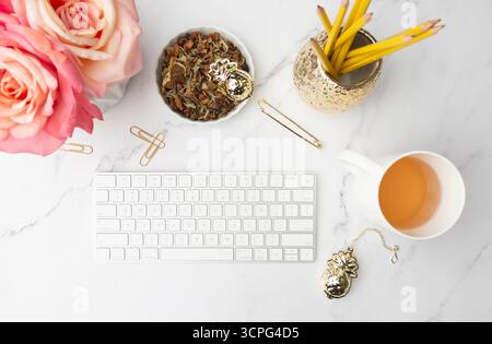 Vue de dessus de bureau féminine avec tasse de thé et de fleurs Banque D'Images