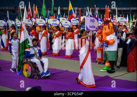 New Delhi, New Delhi, INDE. 25 septembre 2025. Lors du défilé des Nations lors de la cérémonie d'ouverture des Championnats du monde IndianOil New Delhi 2025 de para Athlétisme au Jawaharlal Nehru Stadium, Delhi, un athlète en fauteuil roulant de l'Inde porte le drapeau national tandis qu'un volontaire mène avec l'affiche IND. La mascotte colorée se tient à côté d'un extincteur alors que des volontaires tenant des pancartes pour le Cameroun, le Chili, la Colombie, Hong Kong (Chine) et le Mexique s'alignent en arrière-plan. (Crédit image : © Ankit Roy Majumder/ZUMA Press Wire) USAGE ÉDITORIAL SEULEMENT ! Non destiné à UN USAGE commercial ! Banque D'Images