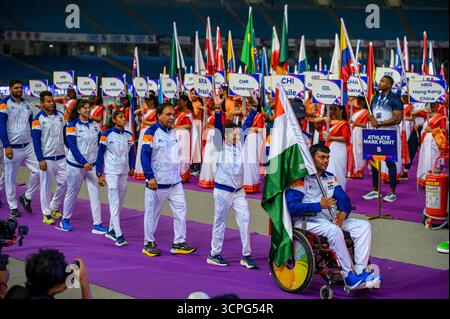 New Delhi, New Delhi, INDE. 25 septembre 2025. Lors du défilé des Nations lors de la cérémonie d'ouverture des Championnats du monde IndianOil New Delhi 2025 de para Athlétisme au Jawaharlal Nehru Stadium, Delhi, un athlète en fauteuil roulant de l'Inde porte le drapeau national tandis qu'un volontaire mène avec l'affiche IND. La mascotte colorée se tient à côté d'un extincteur alors que des volontaires tenant des pancartes pour le Cameroun, le Chili, la Colombie, Hong Kong (Chine) et le Mexique s'alignent en arrière-plan. (Crédit image : © Ankit Roy Majumder/ZUMA Press Wire) USAGE ÉDITORIAL SEULEMENT ! Non destiné à UN USAGE commercial ! Banque D'Images