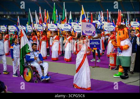 New Delhi, New Delhi, INDE. 25 septembre 2025. Lors du défilé des Nations lors de la cérémonie d'ouverture des Championnats du monde IndianOil New Delhi 2025 de para Athlétisme au Jawaharlal Nehru Stadium, Delhi, un athlète en fauteuil roulant de l'Inde porte le drapeau national tandis qu'un volontaire mène avec l'affiche IND. La mascotte colorée se tient à côté d'un extincteur alors que des volontaires tenant des pancartes pour le Cameroun, le Chili, la Colombie, Hong Kong (Chine) et le Mexique s'alignent en arrière-plan. (Crédit image : © Ankit Roy Majumder/ZUMA Press Wire) USAGE ÉDITORIAL SEULEMENT ! Non destiné à UN USAGE commercial ! Banque D'Images