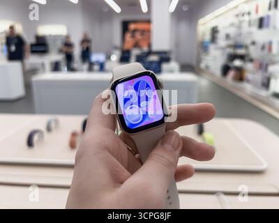 Poznan, Pologne - 20 septembre 2025 : Apple Watch se 3, un appareil intelligent élégant, tenu à la main, mettant en évidence son interface de mouvement liquide coloré dans un mode Banque D'Images