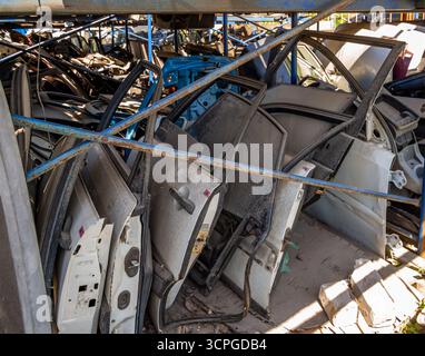 Rack avec de vieilles portes de voiture dans une cour de démontage de voiture Banque D'Images