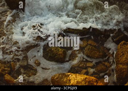 De fortes vagues océaniques se brisent contre la rive rocheuse avec un paysage côtier naturel. Photo de haute qualité Banque D'Images