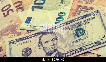 Vue rapprochée des billets en euros et en dollars américains, avec un billet de 100 euros et 50 euros accompagné d'un billet de 5 dollars américains. L'image met en évidence des événements internationaux Banque D'Images