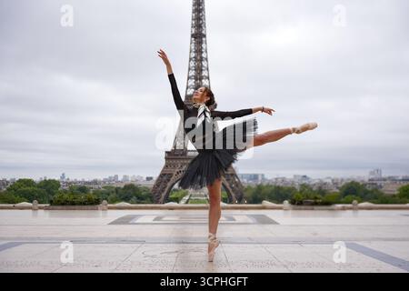 Ballerine dansant gracieusement devant la Tour Eiffel à Paris Banque D'Images