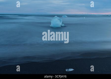 Diamond Beach, Fellsfjara, par Jökulsárlón : glace scintillante sur sable noir avec surf atlantique dans le parc national de Vatnajökull, au sud de l'Islande. Banque D'Images