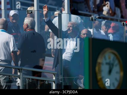 Farmingdale, États-Unis. 26 septembre 2025. Le président Donald Trump agite à la foule derrière un mur de verre pare-balles alors qu’il arrive pour la journée d’ouverture de la 45e Ryder Cup au Black course du Bethpage State Park à Farmingdale, New York, le vendredi 26 septembre 2025. Photo de John Angelillo/UPI crédit : UPI/Alamy Live News Banque D'Images