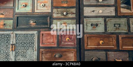 Gros plan sur les tiroirs en bois vintage. Vieux coffre coloré à la main et arrière-plan d'armoires. Banque D'Images