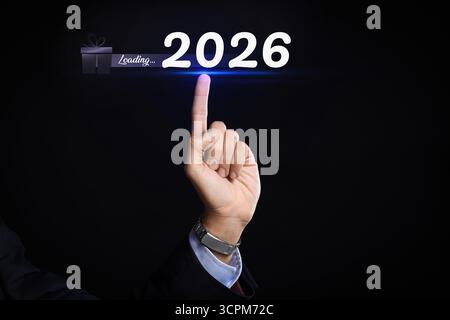 Main de l'homme d'affaires touchant la figure 2026 sur l'écran virtuel sur fond sombre Banque D'Images
