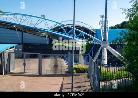 Une vue dégagée sur Kirklees Stadium, Huddersfield, révélant ses sièges bleus, sa structure de toit blanc et ses portes d'entrée par une journée ensoleillée. Banque D'Images