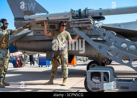 De gauche à droite, l'aviateur de la 1re classe de l'US Air Force Adrion Hurd, le 55e Escadron expéditionnaire de génération de chasseurs chargent des armes membre de l'équipage, et le sergent d'état-major Oscar Banque D'Images