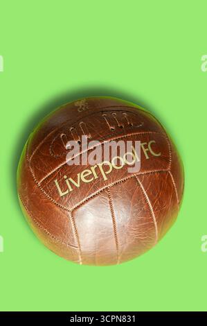 Football en cuir de style vintage avec la marque Liverpool FC sur fond vert Banque D'Images