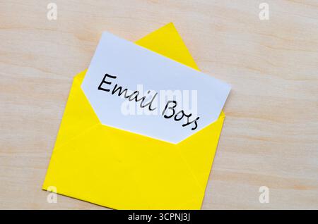 Email Boss texte imprimé sur papier blanc à l'intérieur de l'enveloppe jaune vide sur la surface en bois Banque D'Images