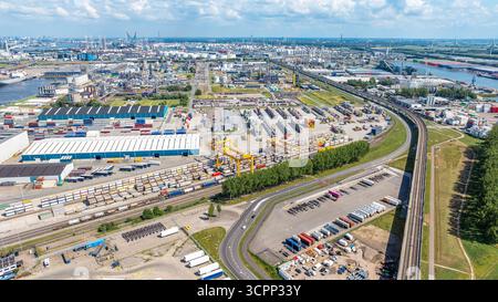 Vue aérienne de la zone industrielle dans la ville hollandaise avec la rivière le jour ensoleillé avec l'horizon nuageux. Routes, ponts, entrepôts industriels et bâtiments, windmil Banque D'Images