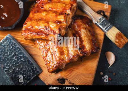 Côtes de rechange grillées chaudes épicées d'un barbecue d'été servies avec un piment chaud et des tomates fraîches Banque D'Images
