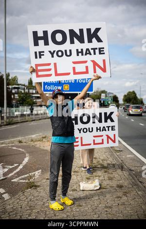 Londres, Royaume-Uni. 27 septembre 2025. Des activistes du groupe de campagne Tesla Takedown manifestent devant le showroom Tesla dans l'ouest de Londres près de la gare Park Royal le 27 septembre 2025. Les manifestants portaient des pancartes et des banderoles contre Elon Musk, condamnant son récent discours vidéo à la marche d'extrême droite Unite the Kingdom à Londres. Les militants ont accusé Musk d'alimenter les mouvements d'extrême droite et anti-immigrés au Royaume-Uni. (Photo de Pete Speller/Sipa USA) crédit : Sipa USA/Alamy Live News Banque D'Images