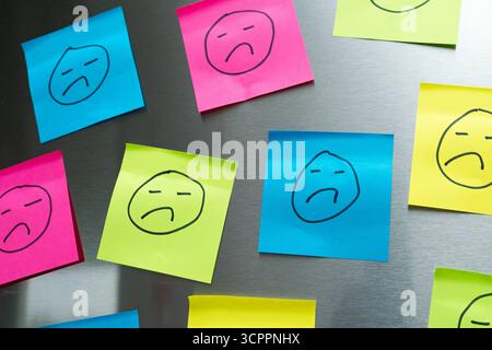 Allemagne - 27 septembre 2025 : de nombreux visages tristes sur les Post-it illustrent les réactions négatives, les critiques médiocres en ligne et le mécontentement des clients à l'ère numérique. *** Viele traurige Gesichter auf Post-its verdeutlichen Negative Feedbacks, schlechte Online-Bewertungen und Kundenunzufriedenheit im digitalen Zeitalter. Banque D'Images