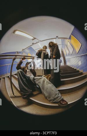 Fish Eye Lens portrait d'amis masculins et féminins posant sur les marches dans le métro Banque D'Images