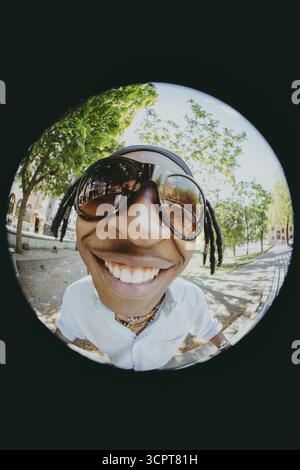 Gros plan d'un jeune homme à la mode heureux portant des lunettes de soleil sur Fish Eye photo Banque D'Images
