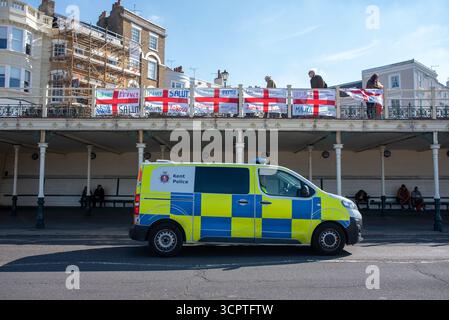 Margate, Royaume-Uni. 27 septembre 2025. Un fourgon de police passe devant les drapeaux de George avec le mot 'Bienvenue' dans différentes langues. Des centaines de contre-manifestants antifascistes se sont rassemblés pour s'opposer et arrêter la marche anti-immigration de l'UKIP (United Kingdom Independence Party) à travers la ville jusqu'à l'hôtel de réfugiés à Margate. Crédit : SOPA images Limited/Alamy Live News Banque D'Images
