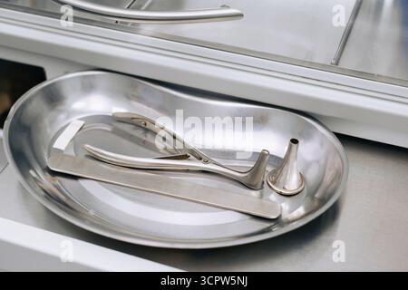 Gros plan des instruments ORL métalliques sur plateau médical en clinique. Outils d'oto-rhino-laryngologie pour l'examen et les interventions de l'oreille, du nez et de la gorge Banque D'Images