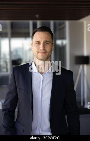 Portrait d'un bel homme d'affaires, entraîneur ou fondateur d'entreprise posant à l'intérieur Banque D'Images