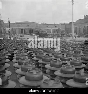 Un vaste champ d'isolateurs en céramique haute tension finis couvre la cour de stockage extérieure de l'armature et de l'usine d'isolation de Slavyansk (AIZ), prête pour l'expédition, avec des bâtiments d'usine en arrière-plan, vers 1970s. Cette impressionnante photographie vintage en noir et blanc de Sloviansk, en RSS d'Ukraine, illustre avec force l'immense ampleur de la production de masse soviétique, mettant en valeur la dernière étape du processus de fabrication et la logistique d'une entreprise industrielle clé, un témoignage étonnant de la puissance productive de la région pacifique du Donbass avant la guerre Banque D'Images