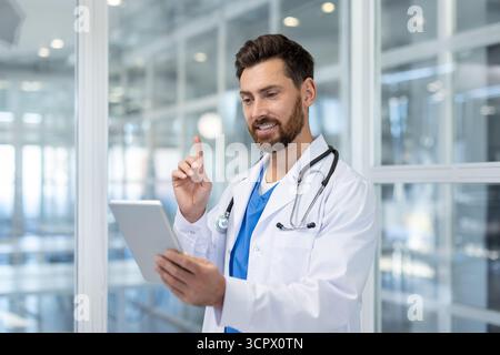 Médecin parlant et fournissant des conseils de santé lors d'une consultation virtuelle à l'aide d'une tablette numérique, faisant la démonstration de la technologie des télécommunications et de la télémédecine moderne Banque D'Images