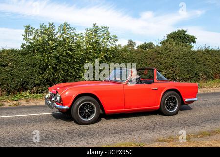 Années 1964 60 Red Triumph TR4 Sports car Petrol 2138 cc ; amateurs de voitures classiques voyageant à grande vitesse au salon de voitures classiques de Cheshire, Royaume-Uni Banque D'Images