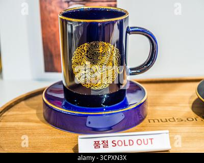 Séoul, Corée du Sud – septembre 2025 : Mug en céramique bleue avec motif Dragon d’or et soucoupe à la boutique de cadeaux du Musée national de Corée Banque D'Images