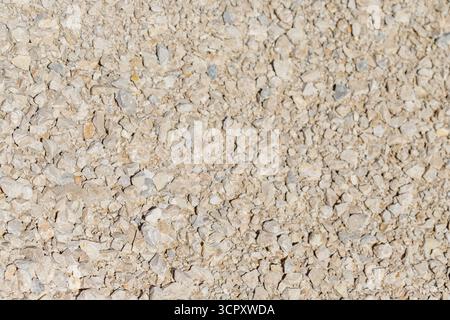 Une photo au-dessus d'une surface couverte de gravier de couleur claire, remplissant tout le cadre. Banque D'Images