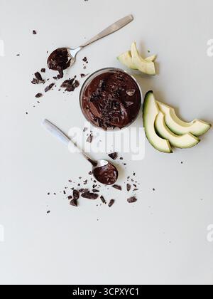 mousse d'avocat au chocolat cru riche et crémeuse servie dans un petit bocal en verre clair ou ramequin. Le dessert sain, végétalien et sans gluten Banque D'Images