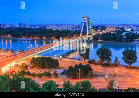 Bratislava, Slovaquie. OVNI ou le pont SNP sur le Danube avec panorama nocturne de Bratislava. Banque D'Images
