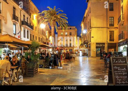 Scène de rue sur la place du Marche dans la vieille ville de Nîmes, France la nuit. Banque D'Images