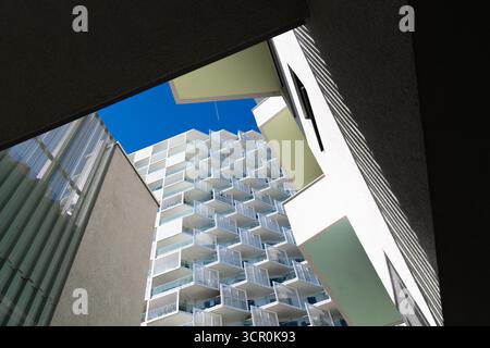 Architecture résidentielle moderne avec balcons répétitifs et façade géométrique sous fond de ciel bleu clair lumineux Banque D'Images