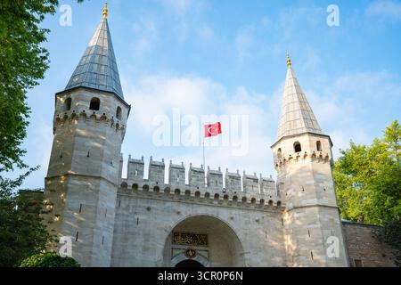 Istabul, Turquie - août 26 2025 : Grande entrée du Palais de Topkapi avec des tours et le drapeau turc sous le ciel bleu. Porte de salutation. Ottoman historique Banque D'Images