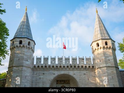 Istabul, Turquie - août 26 2025 : Grande entrée du Palais de Topkapi avec des tours et le drapeau turc sous le ciel bleu. Porte de salutation. Ottoman historique Banque D'Images
