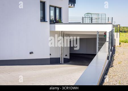Cette scène met en valeur un immeuble résidentiel contemporain avec une grande entrée de garage accessible. La zone environnante est lumineuse, améliorant le Banque D'Images