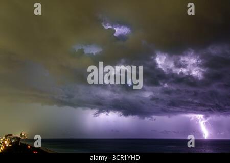 Miami Beach Floride, eau de l'océan Atlantique, nuages de tempête d'orage de foudre de nuit, éclair frappant la lumière vive de l'océan, nuages de tempête sombres illuminés, powe Banque D'Images