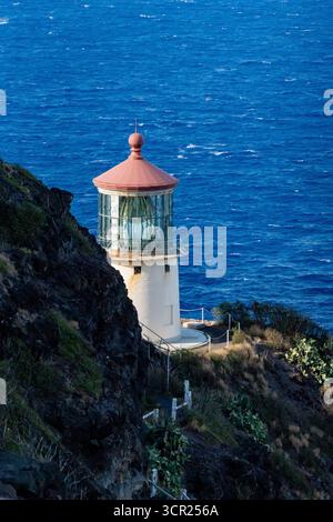 Une vue imprenable sur le phare de Makapu'u sur la côte est de O'ahu, où la riche histoire maritime d'Hawaï rencontre des falaises immaculées et un océan bleu profond Banque D'Images