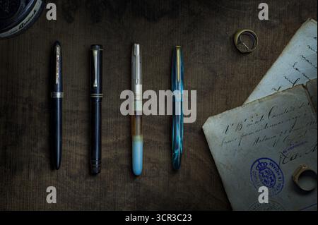 Bureau d'écriture vintage avec stylos à fontaine, lettre, bague et joints affichés sur la surface en bois Banque D'Images