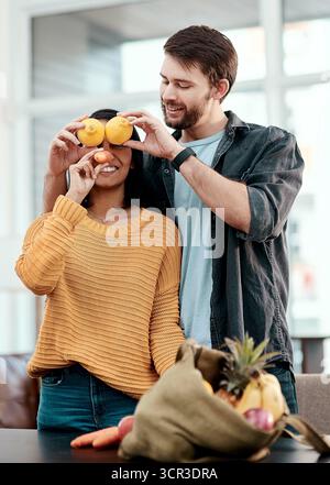 .Épicerie, légumes et drôle avec couple dans la maison pour goofy, liste de courses et supermarché. Nutrition, nourriture et bien-être avec homme et femme ludique Banque D'Images