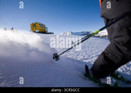Un skieur avec un chat des neiges en arrière-plan. Banque D'Images