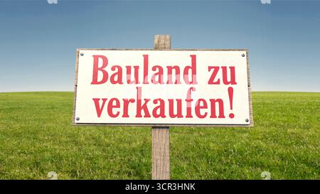 Signez sur un champ vert avec le texte allemand : 'Bauland zu verkaufen' ('terrain à bâtir à vendre !') Banque D'Images