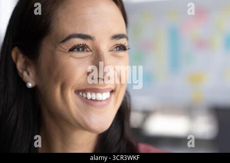 Gros plan portrait de femme souriante regardant loin réfléchi et positivement Banque D'Images