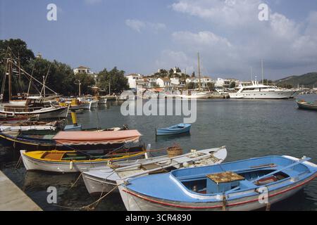 port de l'île de kiathos avec de nombreux bateaux par ville côtière. De nombreux bateaux traditionnels et modernes amarrage dans un port pittoresque de l'île grecque en été 1982. Banque D'Images