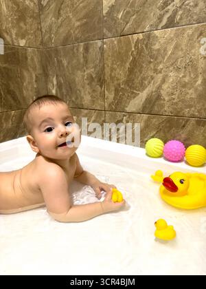 Bébé jouant avec Rubber Ducks dans la baignoire Banque D'Images