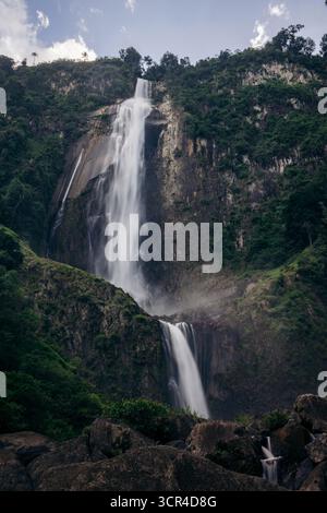 Majestic Air Terjun Nirwana Wartefall descendant une montagne verdoyante sous un ciel bleu vif. Toba, Sumatra du Nord, Indonésie Banque D'Images